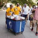 Chancellor Gary S. May and LeShelle May push a cart while helping students move in to campus housing.