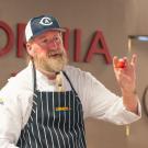 Chef displays a Roma tomato during cooking demonstration