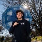 Man stands with umbrella outside