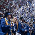 Blue and gold streamers fall upon graduates at commencement