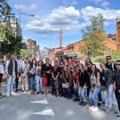 A group poses in front of a brick building. 