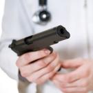 Doctor (white coat, stethoscope) holds gun