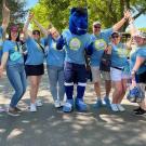 Group of people wearing Give Day shirts pose for photo with Gunrock