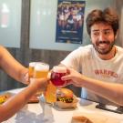 Four people clink their glasses together at restaurant table