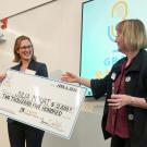 Student stands with giant check made out to Julia Mouat