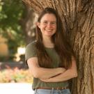 Madeline Bright leans against a tree