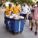 LeShelle May and Gary S. May push a cart filled with a student's belongings during Moove-In.