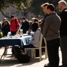 People lower their heads during a moment of silence on the Memorial Union South Patio.