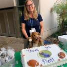 Pint and owner pose for photo in front of cake