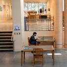 Shields Library interior, with people (in masks) at separate tables