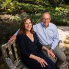 woman and man sitting on bench in park-like setting