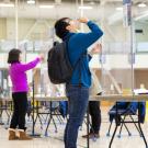 Man takes sip of water for COVID-19 saliva test.