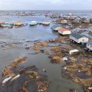 Aerial shot of typhoon-devastated Kipnik, Alaska, showing homes on stilts and rising waters