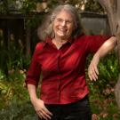 Wendy Kuhn Silk, smiling, leaning against tree
