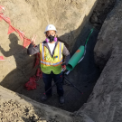 A student in a mask stands in a ditch.