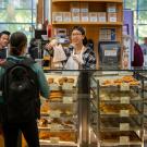 A barista serves a baked good at the Swirlz coffee area of the Coffee House in the Memorial Union at UC Davis.