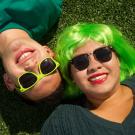 Two students on a green field celebrating spring