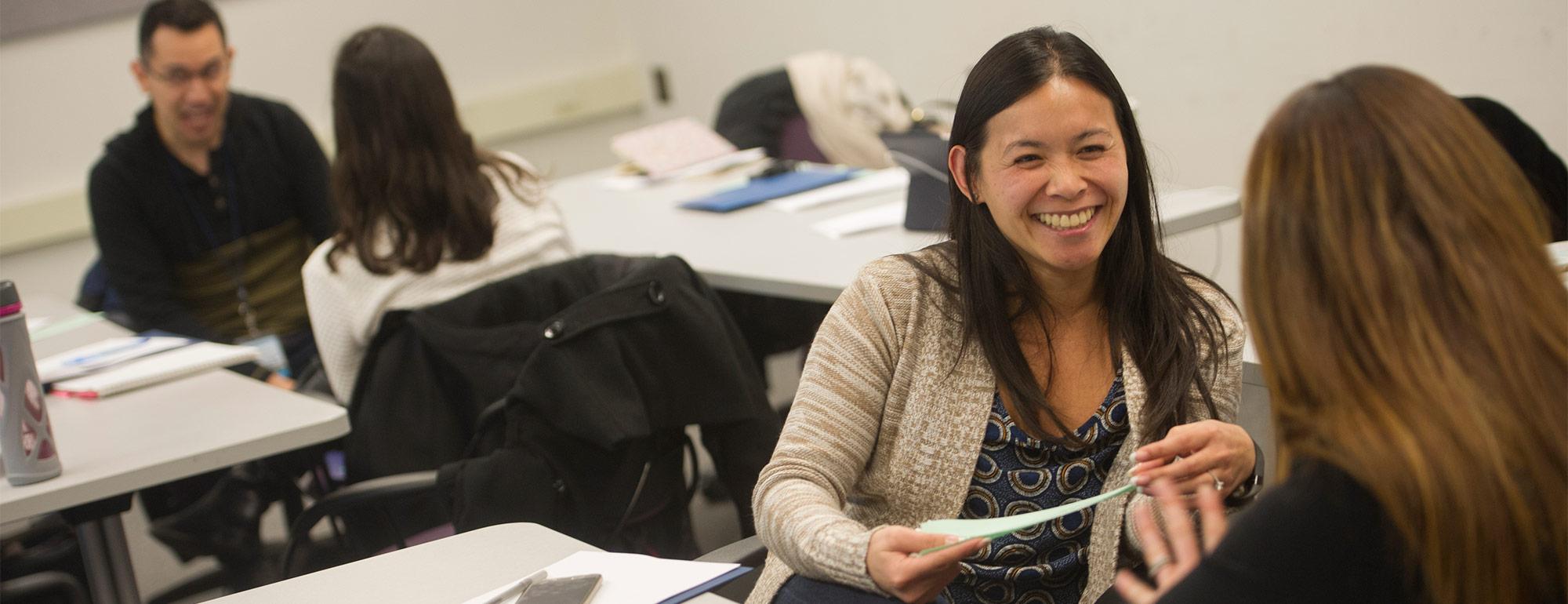 a student chatting with an advisor with another student and advisor in the background