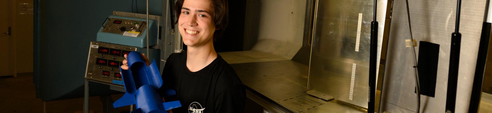 A male student holding a space shuttle model.