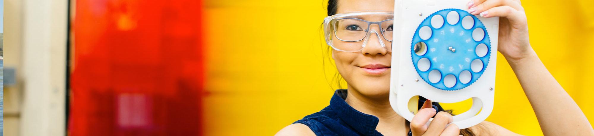 A UC Davis Biomedical Engineering alum poses with here vision improvement invention