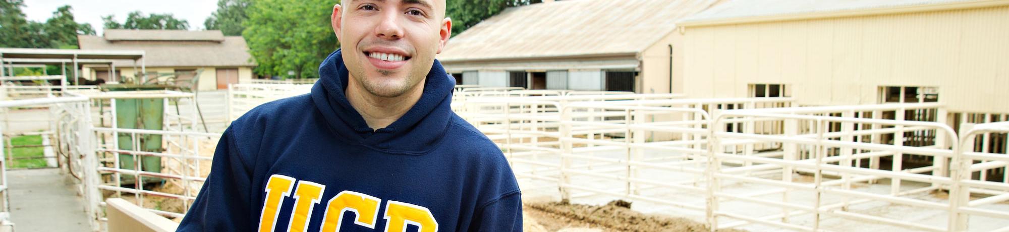 A male student poses at the UC Davis dairy