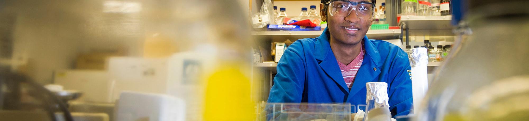 A Cell biology student peeks out from behind the samples he has been working with