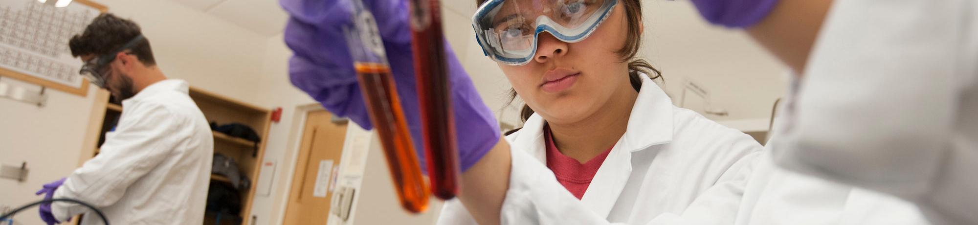 Two female students evaluate the color of a chemical sample