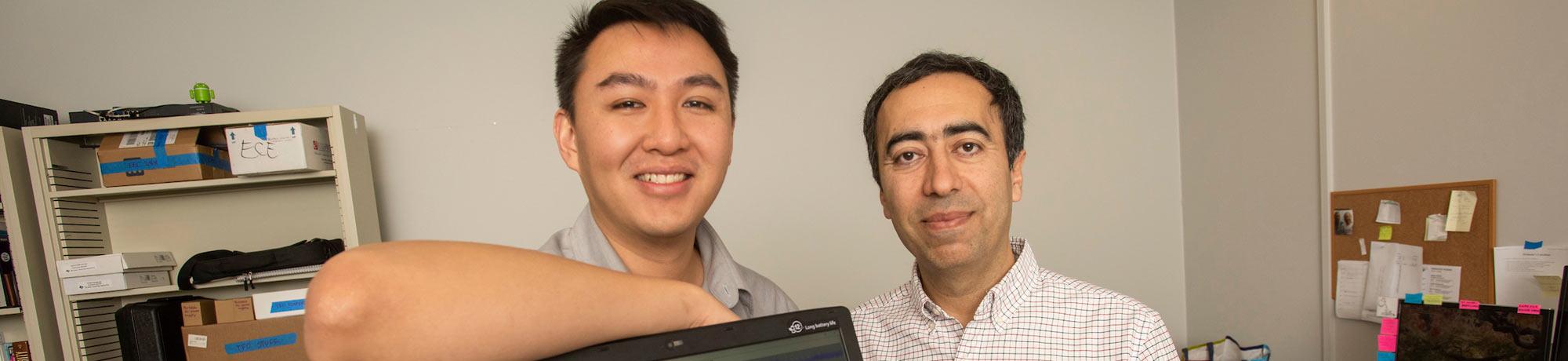 A student and professor pose next to their computer engineering project
