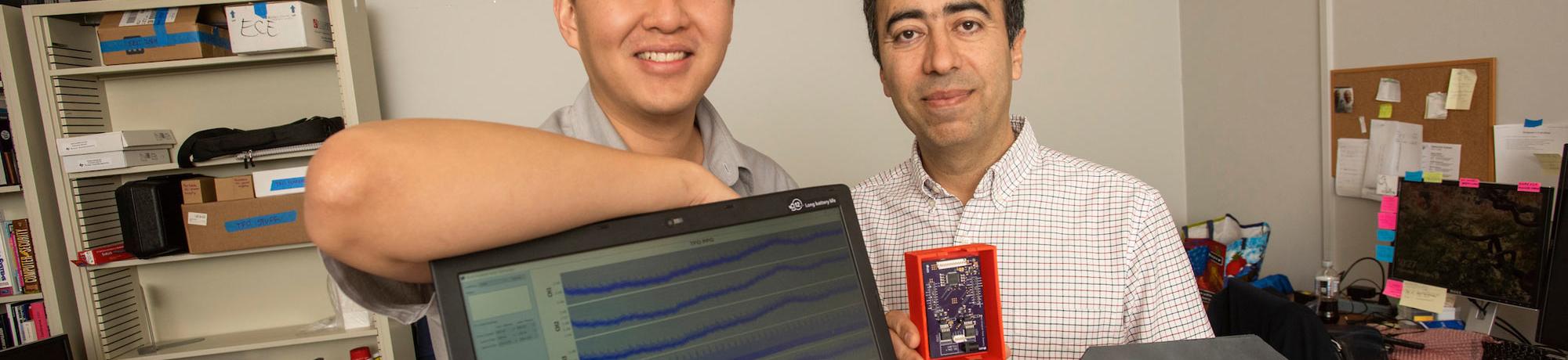 A student and professor pose next to their computer engineering project