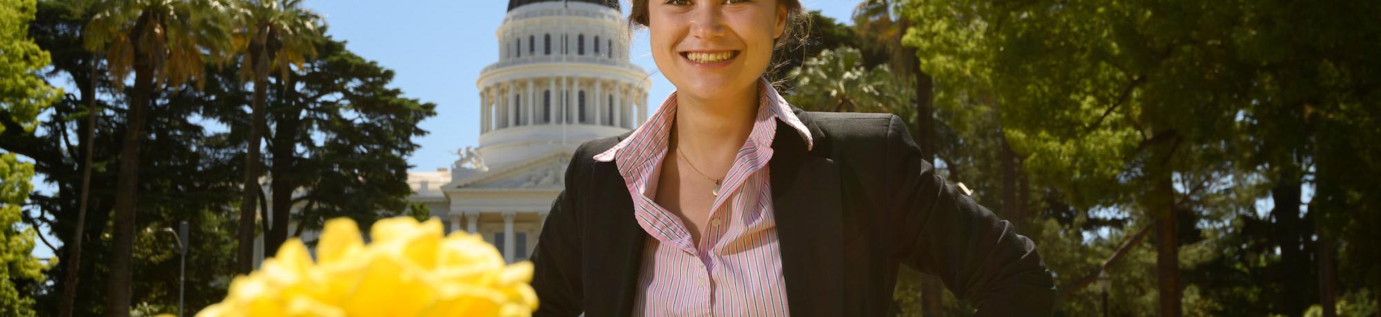 A female student poses in front of the state capitol building