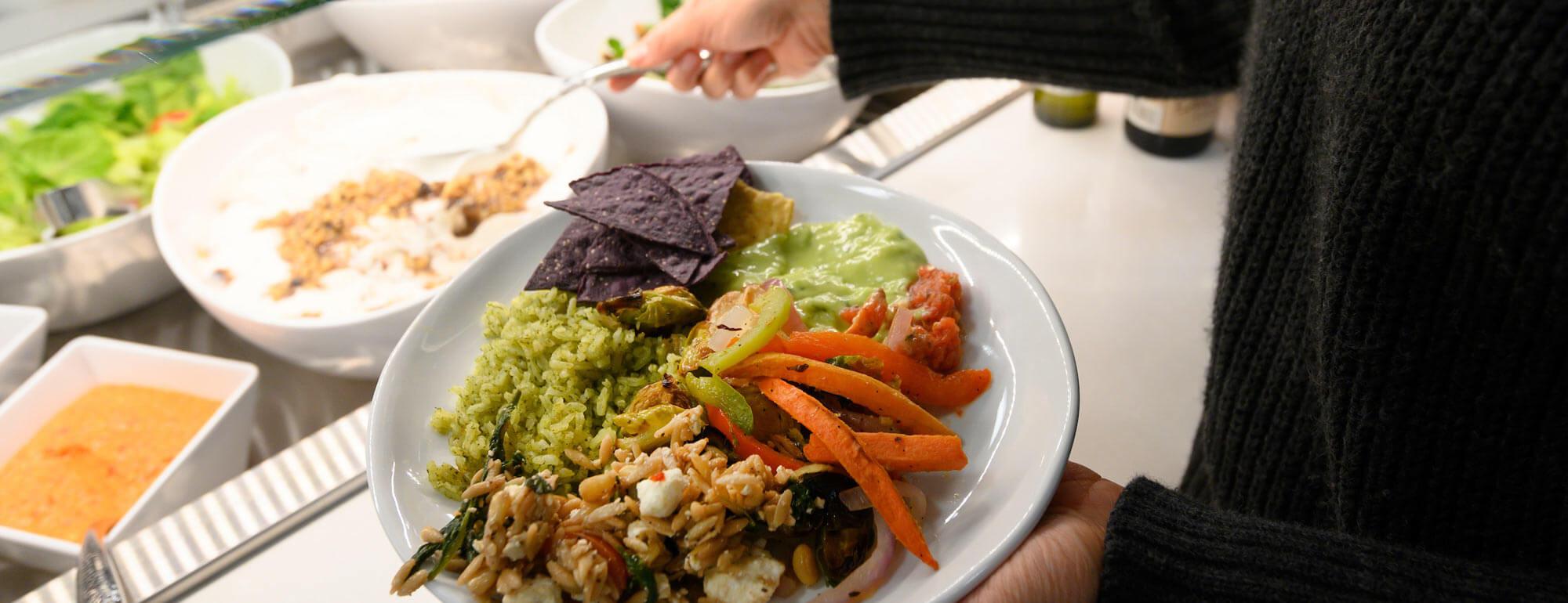 A student loads their plate with delicious food