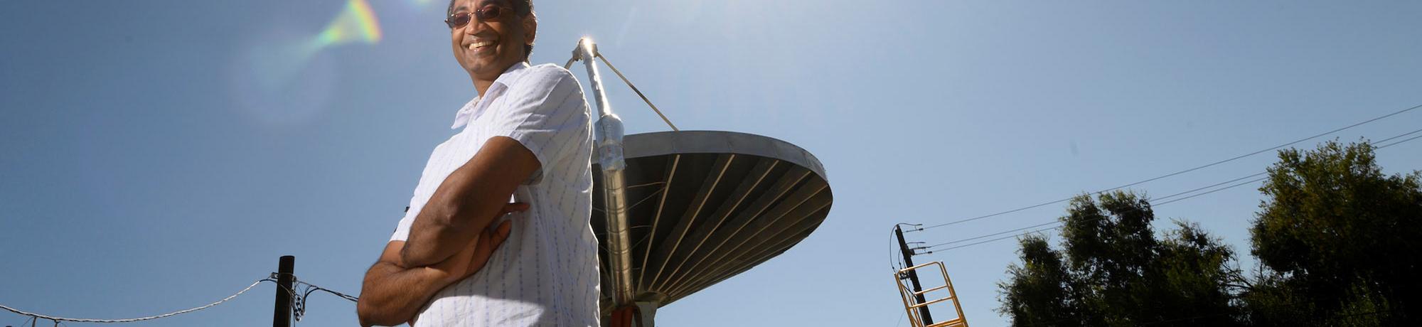 A professor posing in front of a solar heat amplifier.