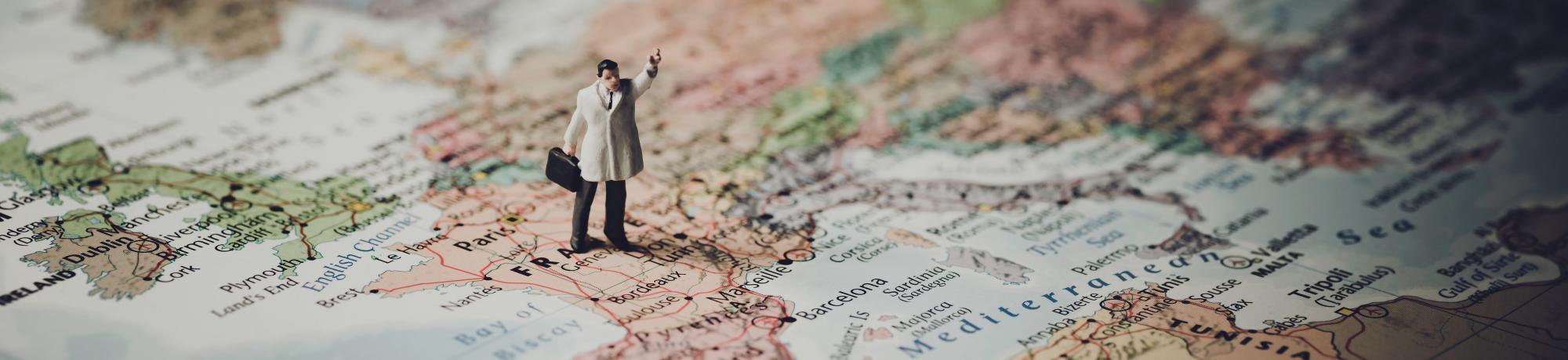 mini action figure stands on France on world map