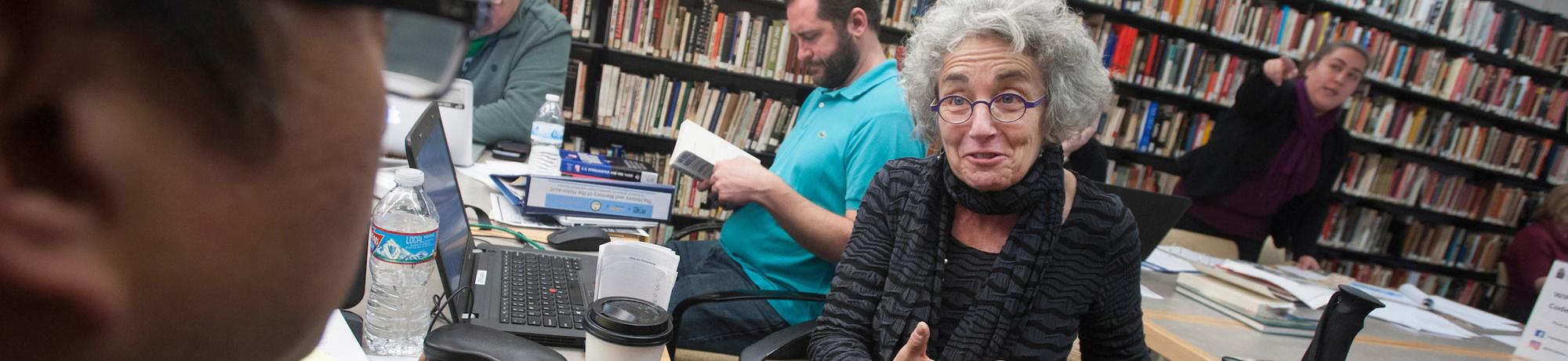 An older women speaks with someone in the foreground