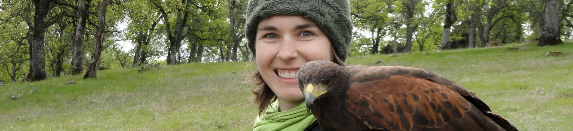 A female student holds a hawk