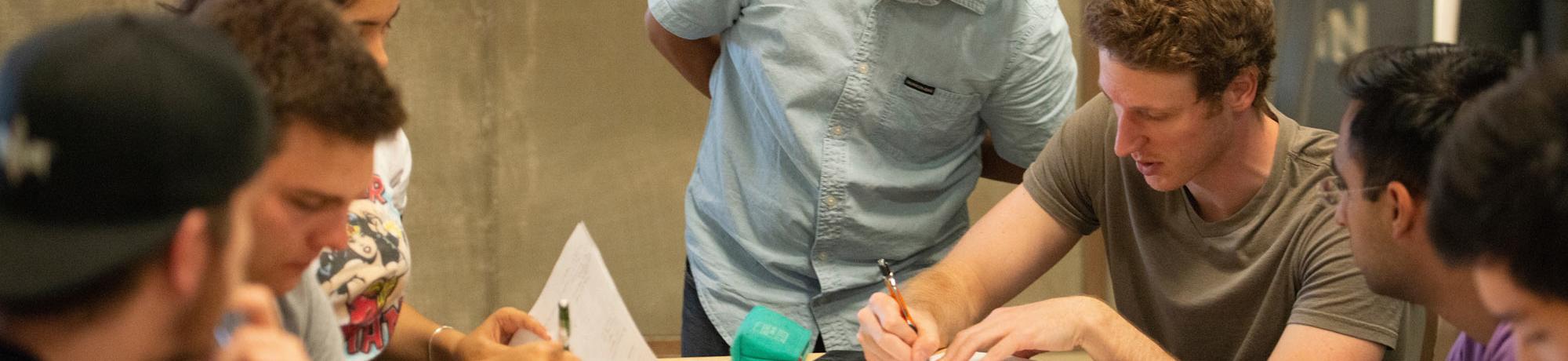 A professor looks over the work of his students