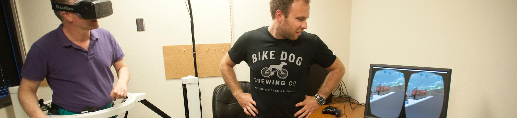 A test subject uses a haptic treadmill will a researcher observes his virtual actions