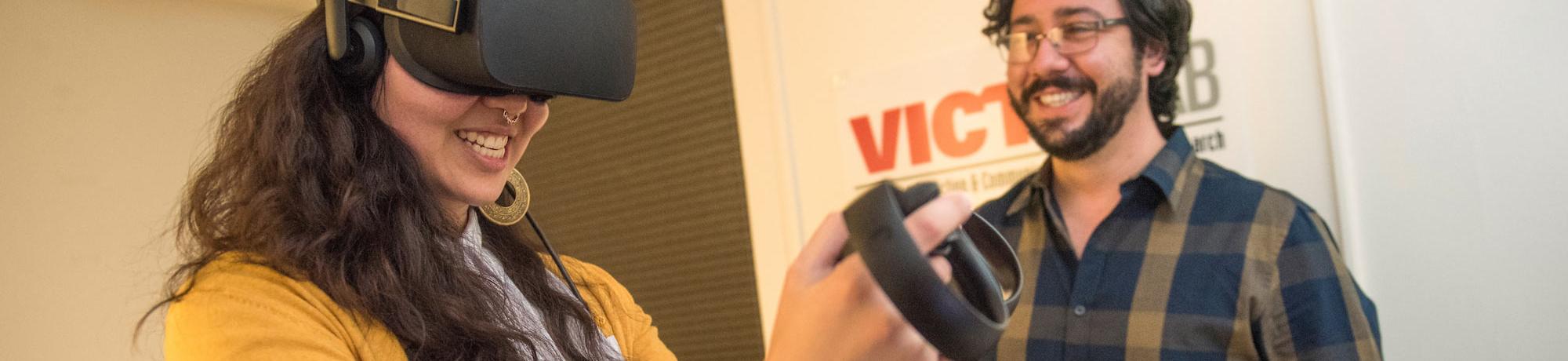 A student smiles while using a virtual reality set up.