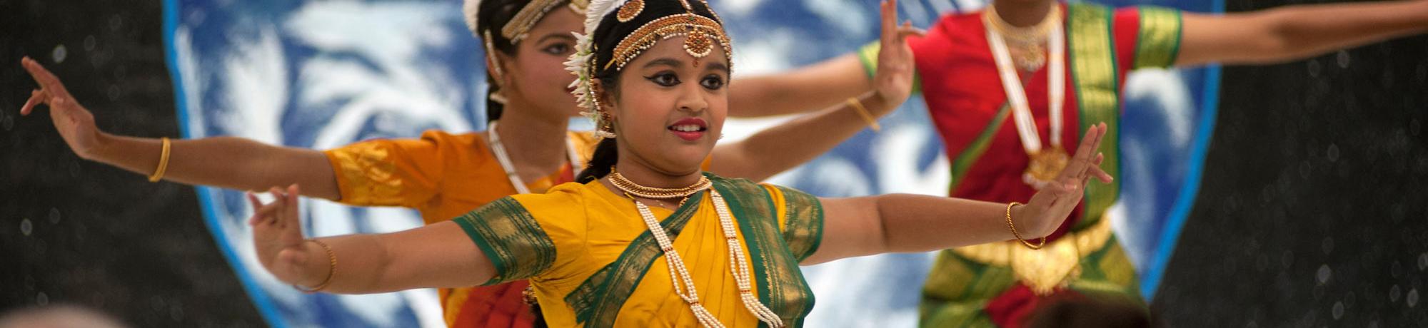 A group of young women preform a South Asian style dance