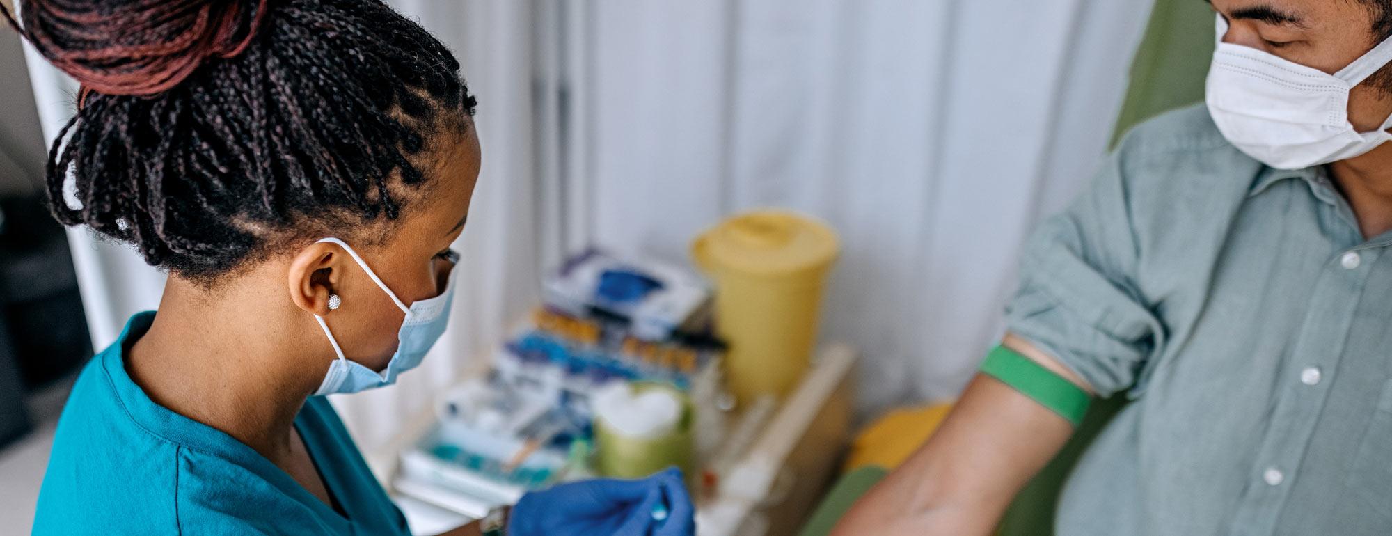 A nurse takes a blood sample from a patient