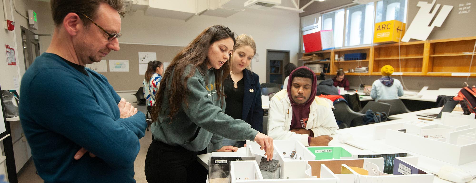 Students discussing a design model with their professor