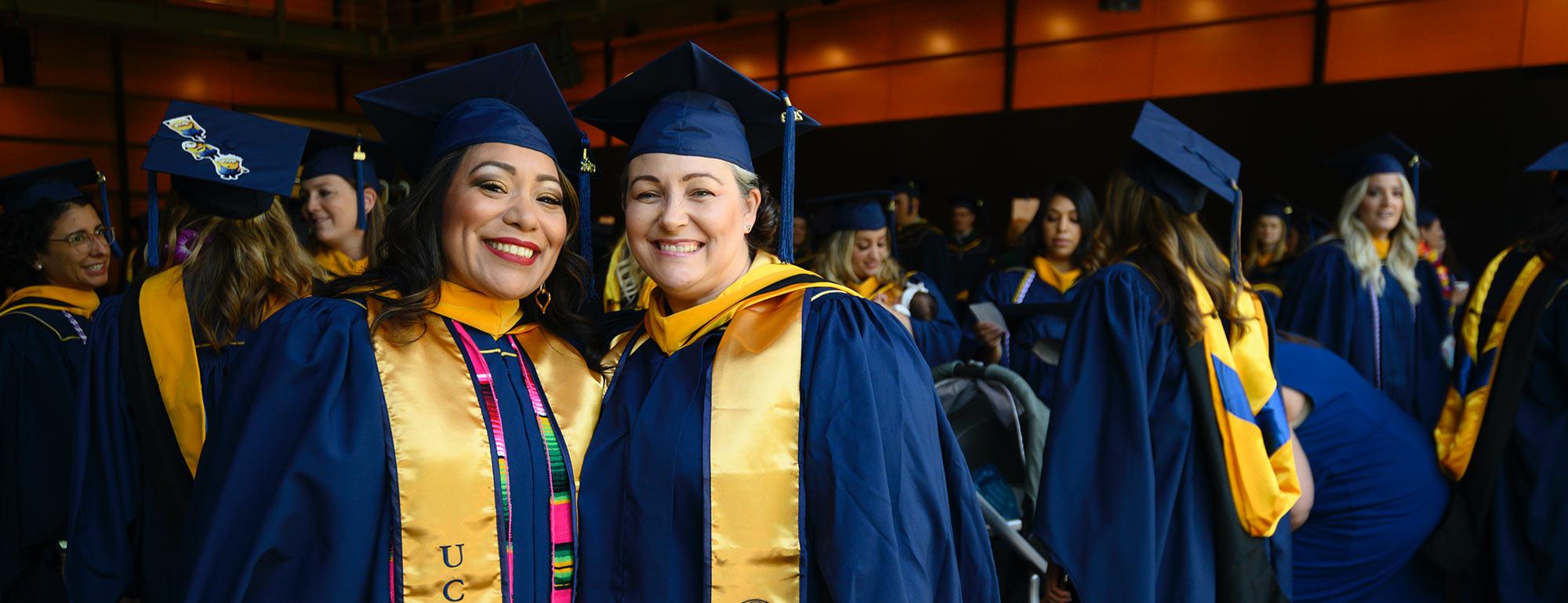 Two nursing school students celebrate during their graduation ceremony