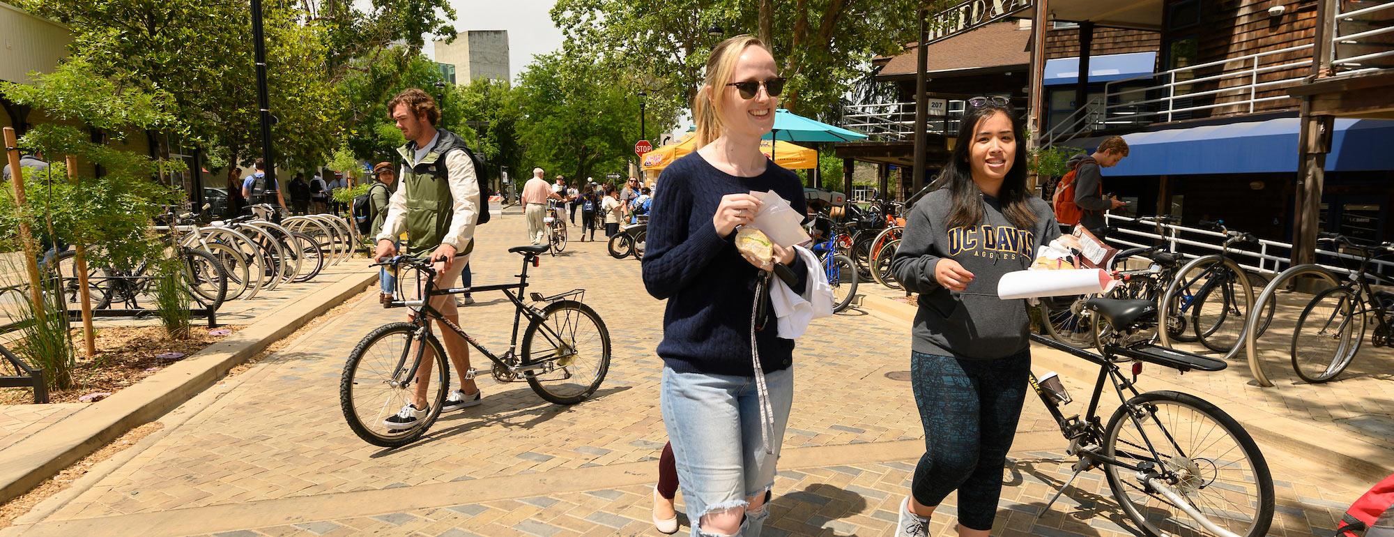 Two female students stroll through downtown Davis, ca