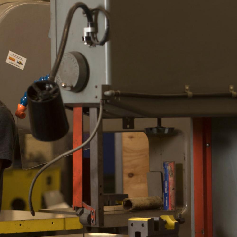 A male student poses with a machine press