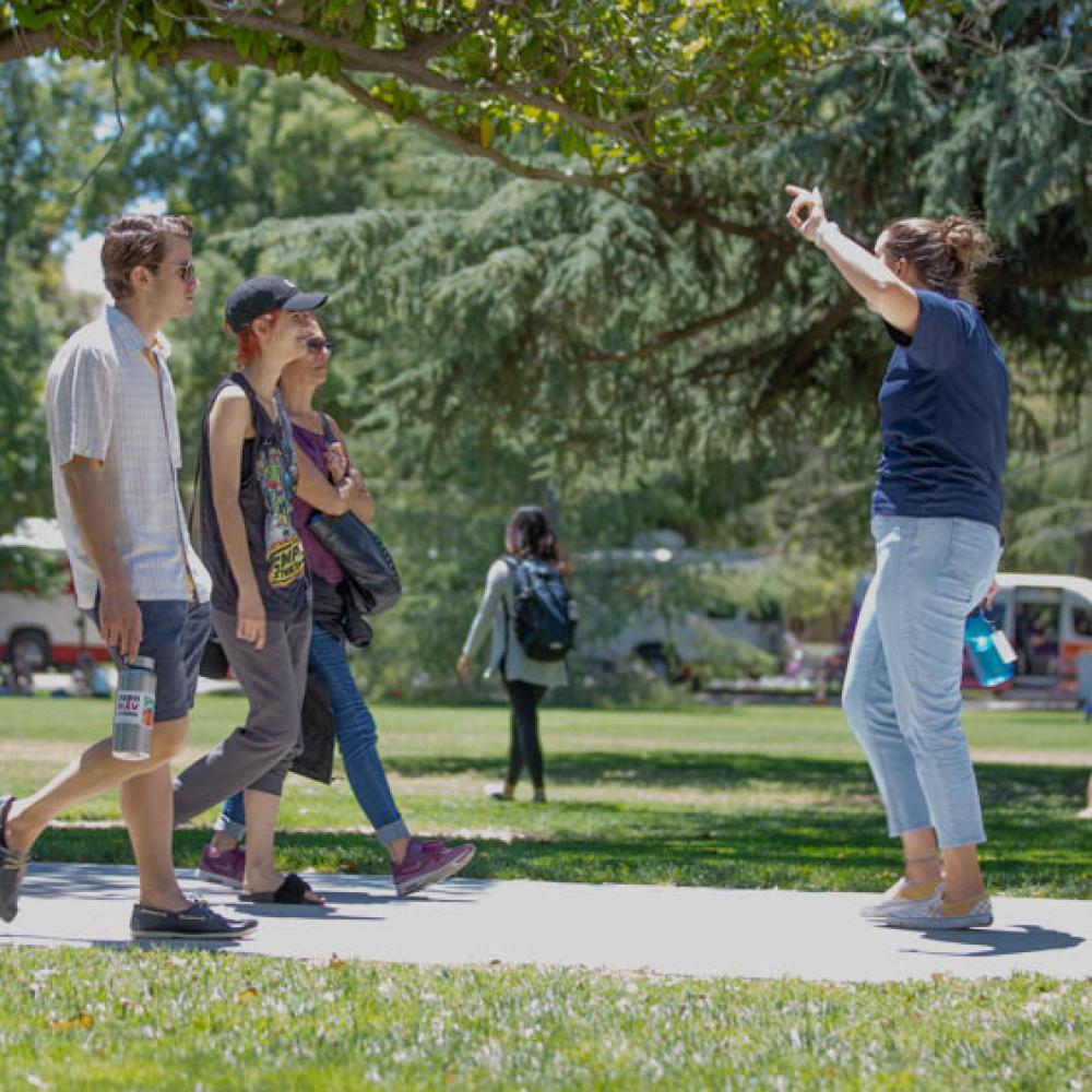 A UC Davis student tour guide leads a family through campus