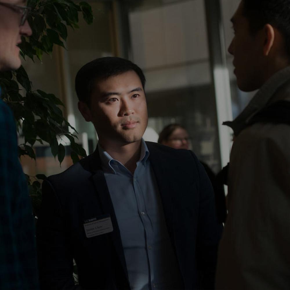 A UC Davis student intently listens to others at an academic gathering