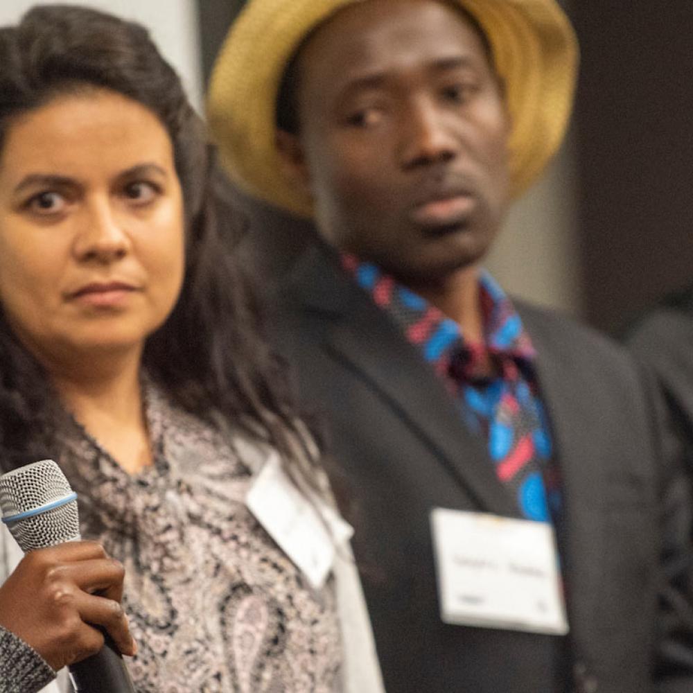 A female student addresses a crowd at the International Center