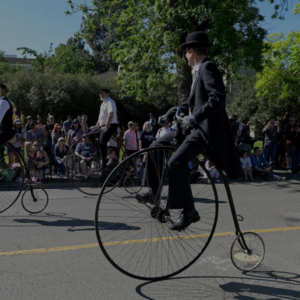 two Davis residents ride Penny Farthing bicycles through campus on Picnic Day