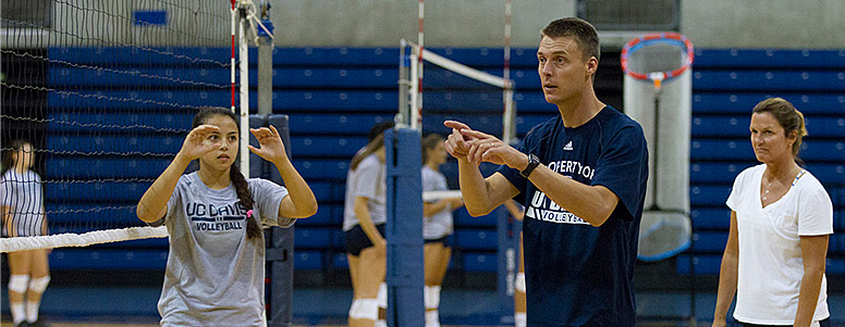 Volleyball coach Dan Conners talking to his team on the court