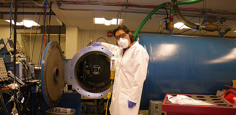 Woman in mask and gown with a large bullet-shaped chamber